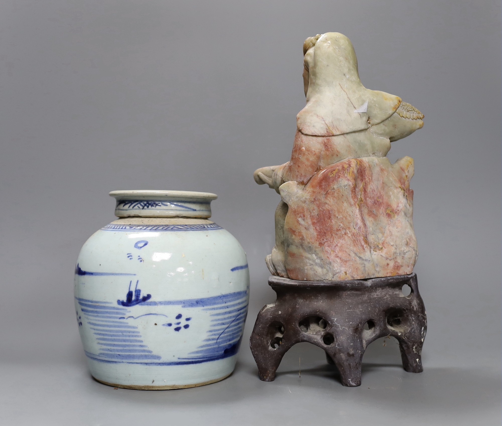 A Chinese soapstone carving of a deity and a similar early 19th century blue and white jar, tallest 30cm